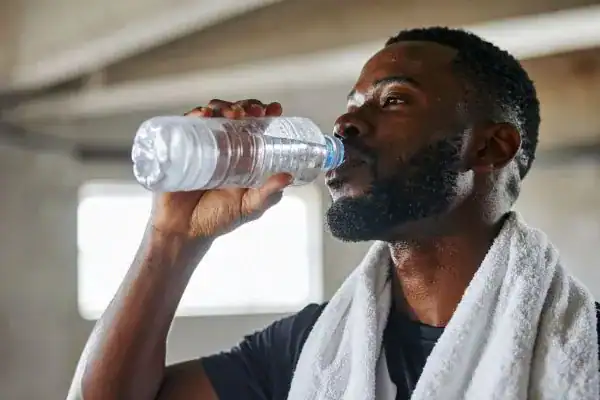 Hydration: The Secret Ingredient for a Toned Stomach and Enhanced Fitness 1 Image of man drinking water to improve hydration Bournemouth after work out.